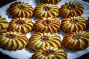 Biscotti al burro friabili disposti su un piatto, con una spolverata di zucchero a velo.