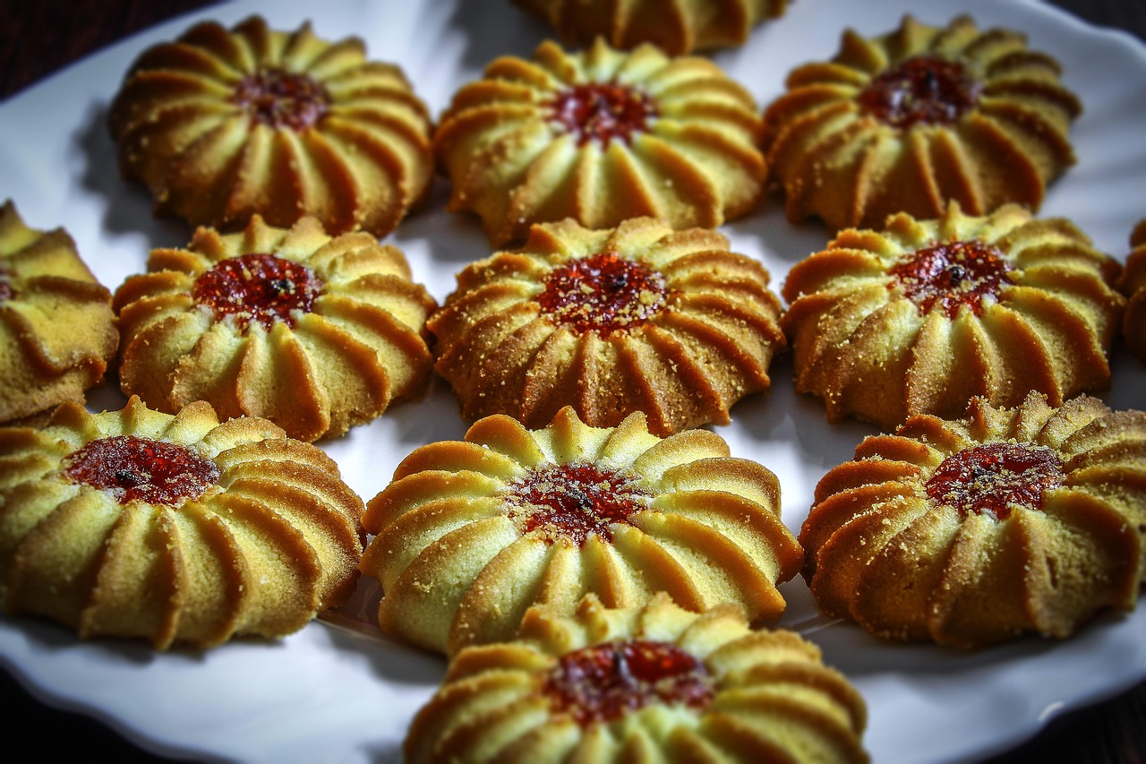 Biscotti al burro friabili disposti su un piatto, con una spolverata di zucchero a velo.