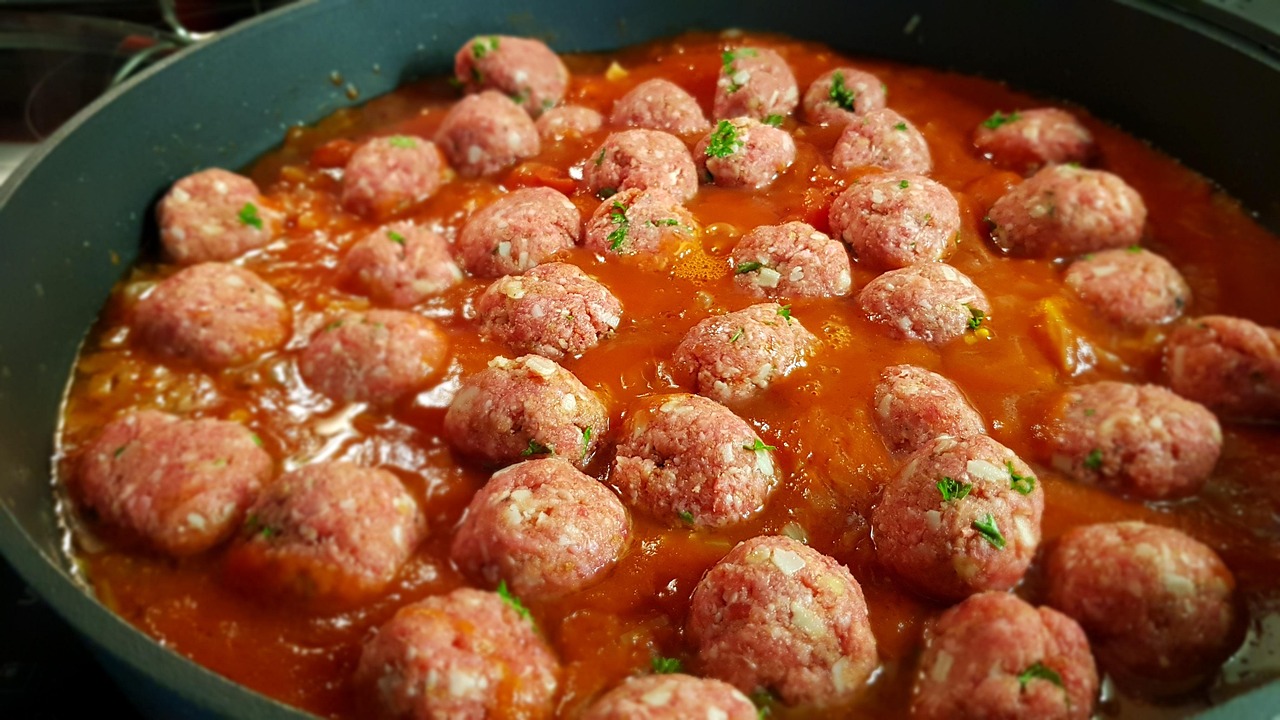 Polpette alla pizzaiola servite con sugo e mozzarella filante, piatto invitante e saporito.