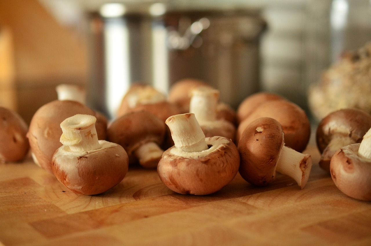 Funghi freschi puliti con un panno umido e spazzolino, pronti per essere cucinati.