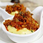 Polenta cremosa con burro e formaggio su un piatto, pronta da gustare.