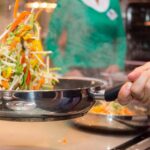 Pentola con soffritto di verdure su fuoco, evidenziando errori comuni nella preparazione.